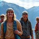 Diverse group of five hikers conversing on a scenic trail, sharing stories.